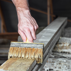 A special brush treats the wood with copper sulfate