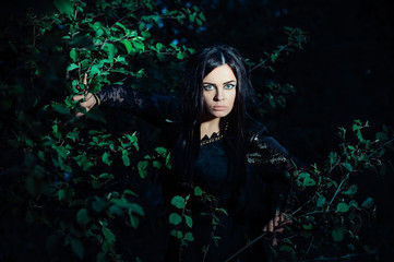 Portrait of a young woman in a black dress in a low key