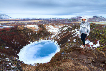 Beautiful woman on the top of the Kerid crater in Iceland in winter © dennisvdwater