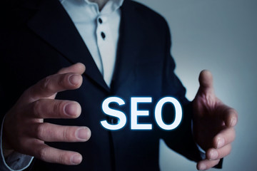 Businessman holding seo word.