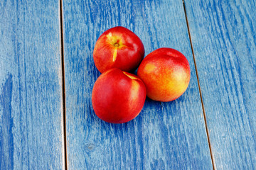 Group of whole nectarine fruits on the wooden background. Peaches are popular fruits for summer.