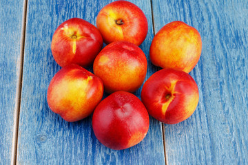 Group of whole nectarine fruits on the wooden background. Peaches are popular fruits for summer.