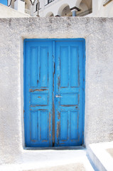 Bright blue old weathered door on the island of Santorini, Greece, Europe.