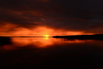 Fiery horizon line at sunset on the lake