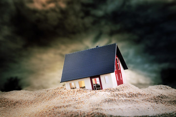 Small model of house in sand