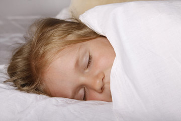 Adorable little girl sleeping in the bed