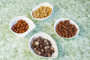 top view of various cereals in colorful bowls