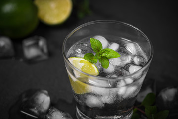 Mojito cocktail with lime and mint in glass on a grey stone background