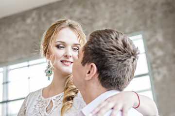 A loving beautiful couple hugging and kissing by the window