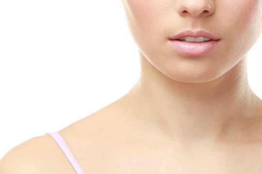 Closeup view of beautiful young woman with natural lips makeup on white background