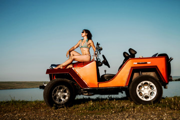 Young woman sitting on the car