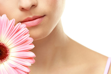 Closeup view of beautiful young woman with natural lips makeup and flower on white background