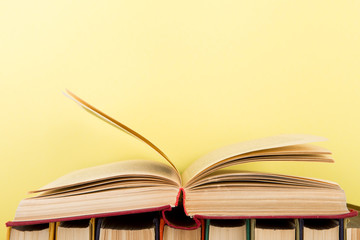 education and wisdom concept - open book on wooden table, color background