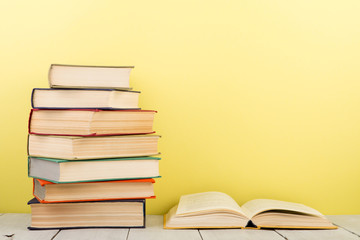 education and wisdom concept - open book on wooden table, color background