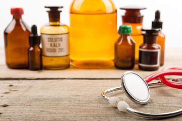 Workplace of doctor - stethoscope and pharmacy bottles on the wooden desk