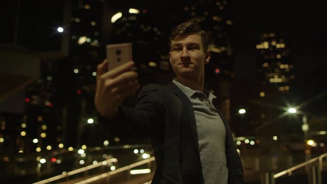 Young male is taking a few selfies on a street