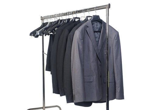 Row Of Men's Suits Hanging In Closet.