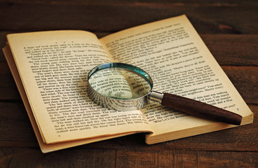 Reading, book and magnifying glass