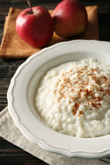 Delicious rice pudding with cinnamon on wooden background
