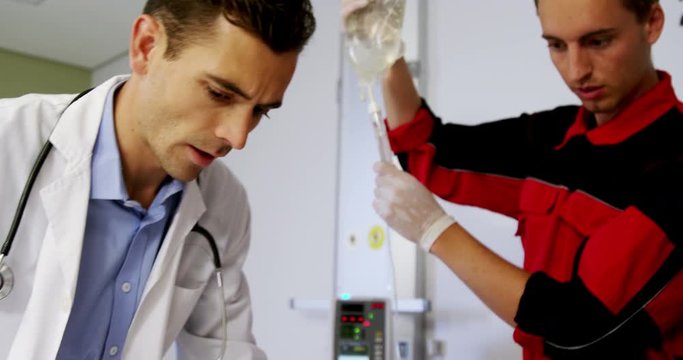 Doctor and paramedic examining a patient in emergency room