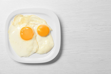 Delicious breakfast with over easy eggs on wooden background