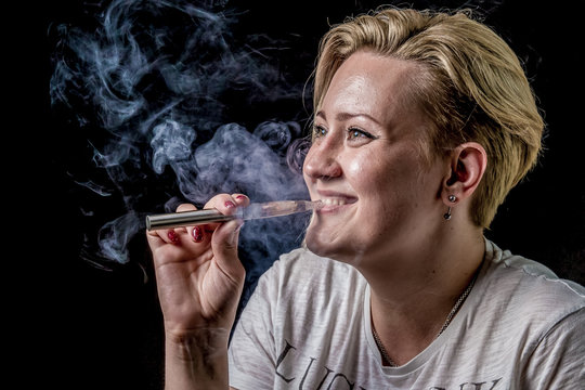 Happy woman smoking electronic cigarette