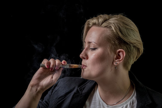 Woman sucking smoke from electronic cigarette