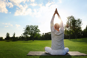 Young man practicing yoga outdoors