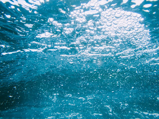 Underwater blue texture in ocean. Bubbles in tropical sea. 
