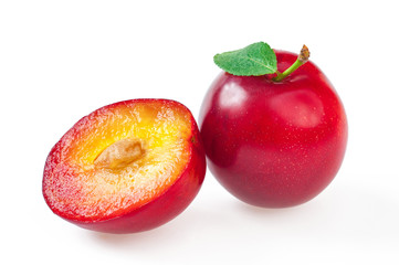 Ripe delicious red plum with leaf, and half cut plum. Close-up, isolated on white