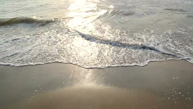 Sea water washes sand on the beach on a sunny day. Beautiful background. The sea is at sunset in the Netherlands, zandvoort