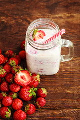 Healthy Strawberry smoothie or milkshake in jar and basket on old rustic background