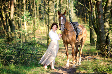 woman walks with the favourite horse in the wood