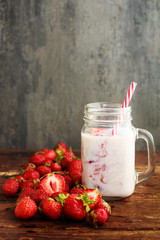 smoothie strawberry or milkshake in jar and basket on old rustic background