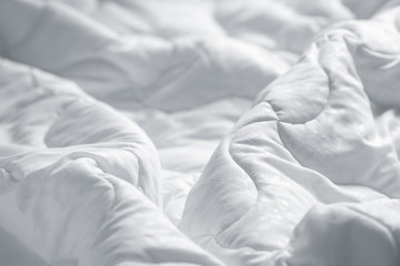 White blanket. Wrinkle messy blanket  in bedroom after waking up in the morning. Bed details. Duvet...