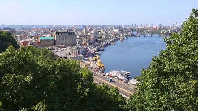 Capital of Ukraine - Kyiv city. Top view of cityscape and blue sky and Dnipro river with beautiful huge green trees in foreground. Real time full hd video footage.