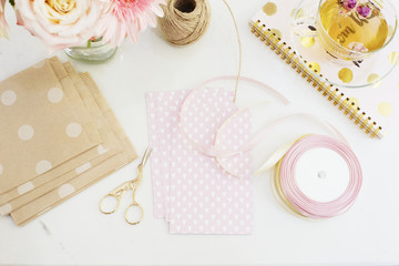 Handmade, craft concept. Materials for making string bracelets and handmade goods packaging - twine, ribbons. Freelance workspace in flat lay style with flowers, rose tea, notebooks 