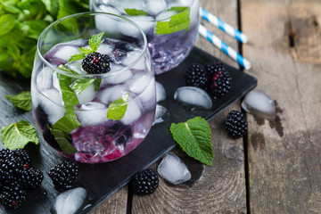 Blackberry mojito and ingredients on rustic background