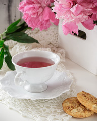 Red berry or fruit tea in teacup with peony