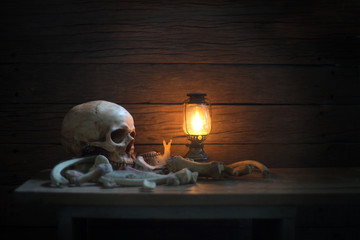 Skull and bone barn and lantern on the plank in dim light / Still Life and virsual art image.