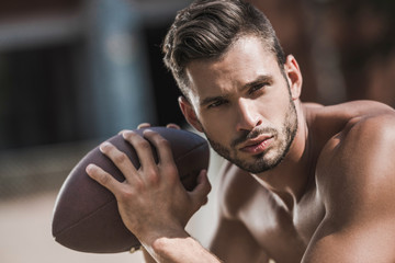 portrait of young handsome male football player with ball © LIGHTFIELD STUDIOS