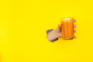 Crop hand holding glass of juice