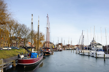 Fototapeta na wymiar Boats and yachts in harbor of litlle historical city in Holland
