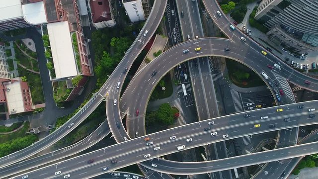 Rotating aerial top down view showing afternoon traffic on a multilevel interchange overpass and elevated road in Shanghai 