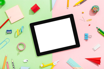 Tablet screen isolated on a pink mint desk. School workspace. Back to school concept. Flat lay
