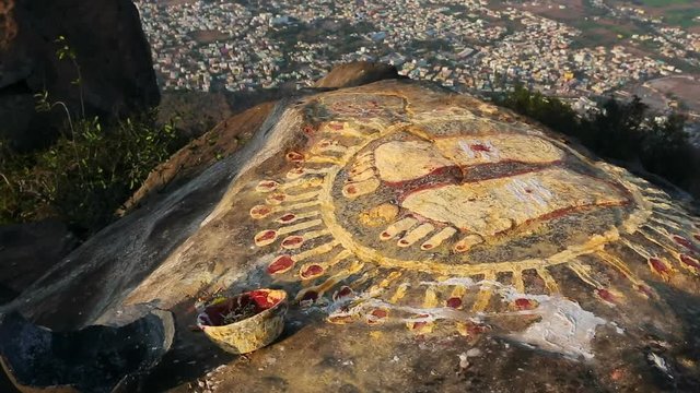 A stone with the image of the footprints of a guru on top of a mountain Arunachala.