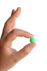 Green tablet taken by two fingers