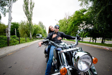 A beautiful couple in love is riding a motorbike.