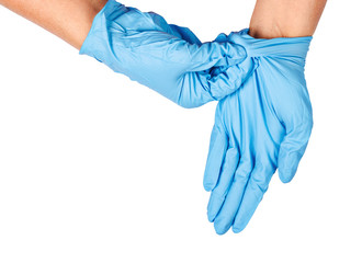 Hand throwing away blue disposable gloves.