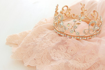 Vintage tulle pink chiffon dress and diamond tiara on wooden white table. Wedding and girl's party...